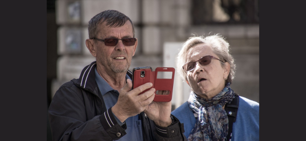 Older couple using a phone on the streets